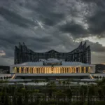Gedung Istana Garuda di Ibu Kota Nusantara (IKN) dengan latar belakang langit mendung yang mencerminkan beban operasional APBN.