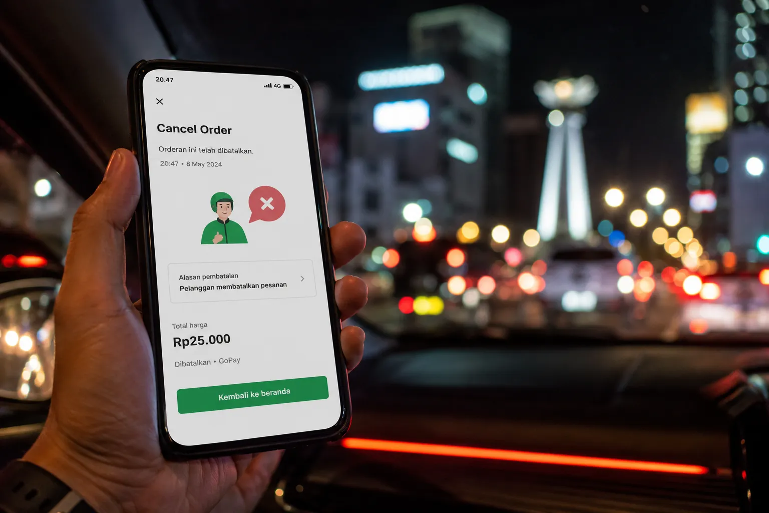 Pengguna menekan tombol batalkan pesanan GoCar di aplikasi Gojek dalam mobil.