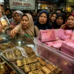 Tumpukan uang kertas rupiah dalam wadah plastik di tengah fenomena maraknya warga jual emas karena himpitan ekonomi.