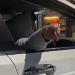 Pengendara wanita menunjukkan kartu anggota kepolisian dengan ekspresi marah di jalan raya.