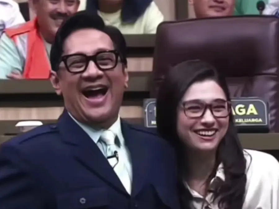 Andre Taulany dan Amanda Rigby tertawa ceria di studio televisi.