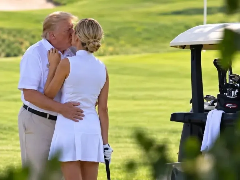 Donald Trump and Natalie Harp sharing a kiss on a golf course.