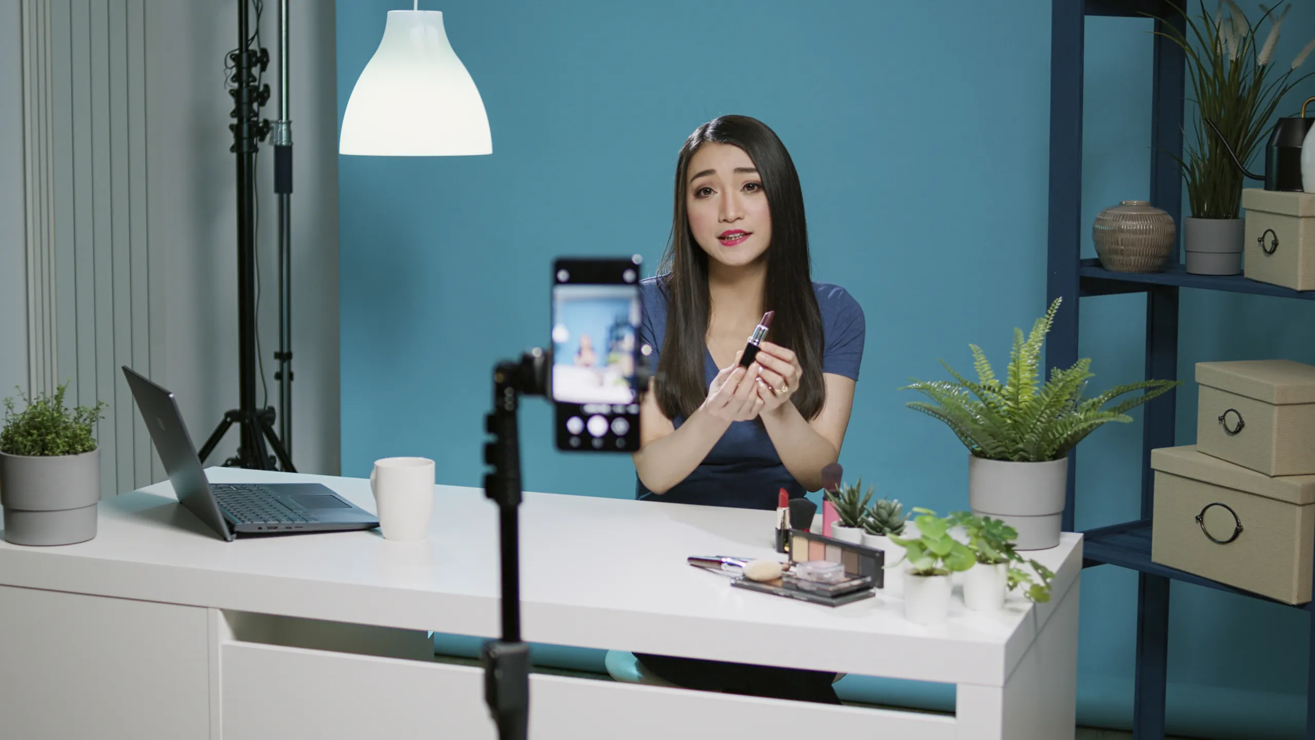 Handphone dengan dashboard TikTok affiliate dan perlengkapan kreator konten di atas meja kerja modern.